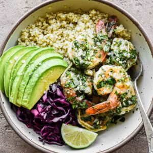 Close up picture of a chimichurri shrimp bowl with all the toppings.