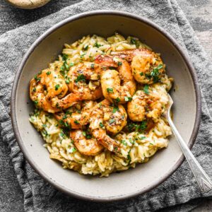 Finished shrimp and rice dish in a bowl with a napkin.