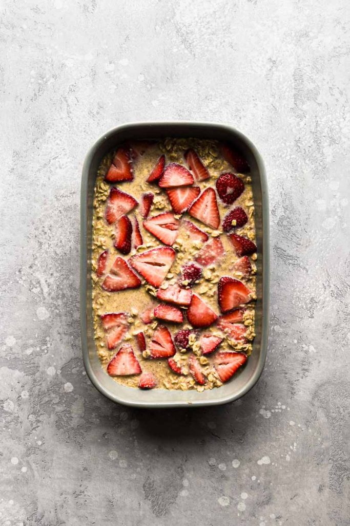 Baked oatmeal in a dish with the strawberries layered in.