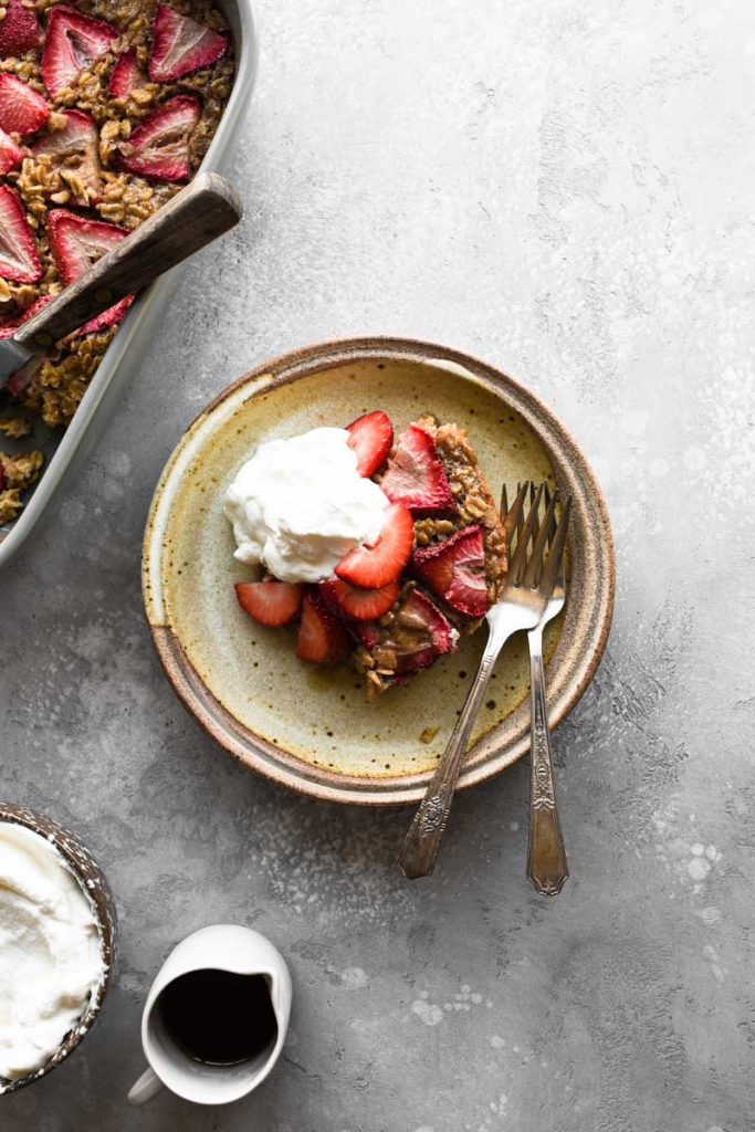 A plate of baked oatmeal with fresh strawberries on top