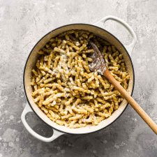 Finished pasta in pot with wood spoon