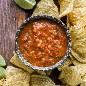Up close of mango habanero salsa in a speckled bowl with chips.