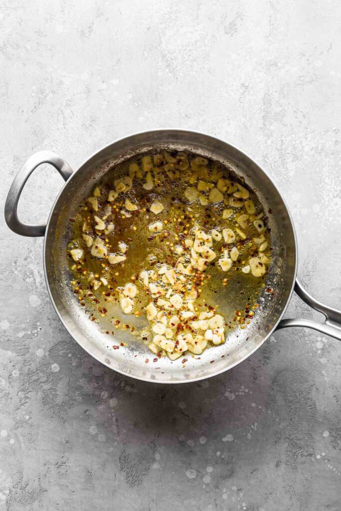 Melted butter, cooking garlic, and red pepper flakes in the pan.