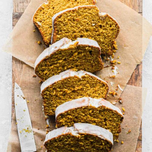 Finished image of maple pumpkin bread sliced on wood board.