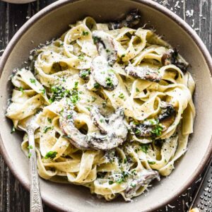 Mushroom mascarpone pasta in a bowl with fresh parsley on top.