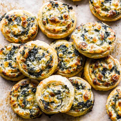 Pile of puff pastry pinwheels on a baking sheet.