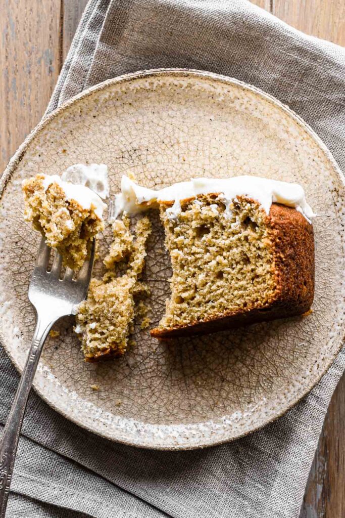 Slice of cake on a plate with a bite taken out.