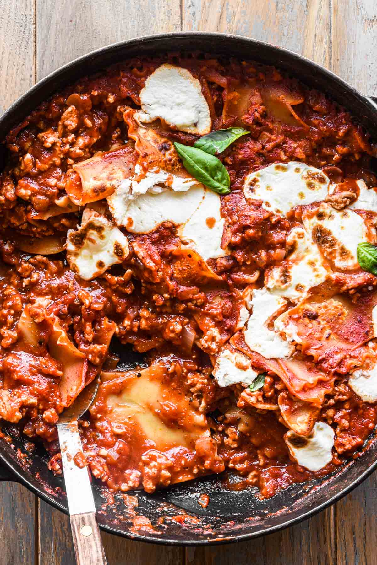 Close up image of broken lasagna with serving spoon.