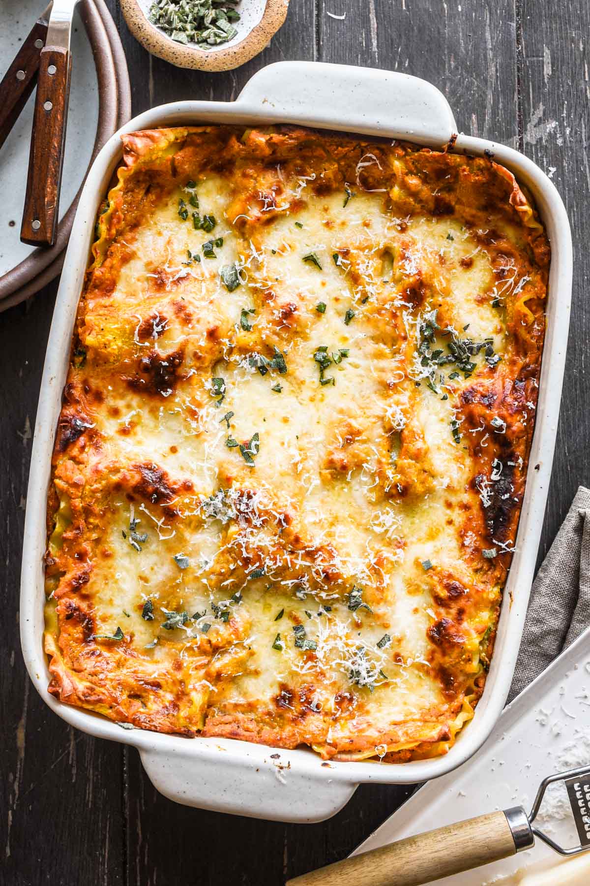 Overhead image of lasagna fresh out of the oven with sage on top.