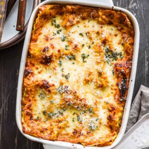 Overhead image of lasagna fresh out of the oven with sage on top.