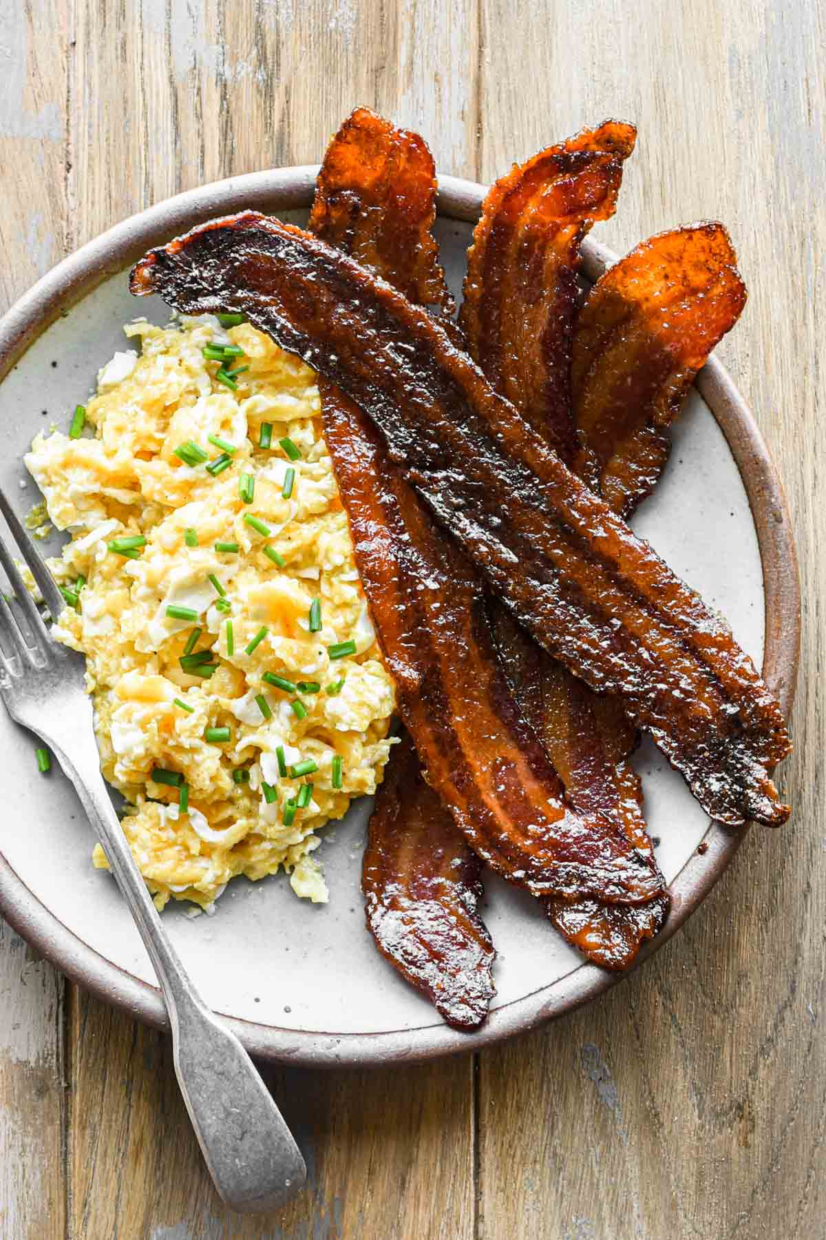 finished bacon on a plate with eggs.