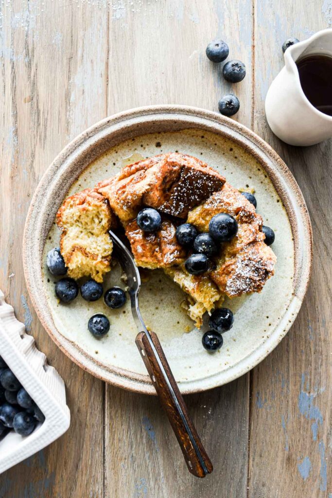 Overhead image of slice of brioche french toast casserole with a bite taken out.