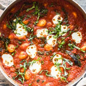 Close up image of finished one pot gnocchi with basil on top.