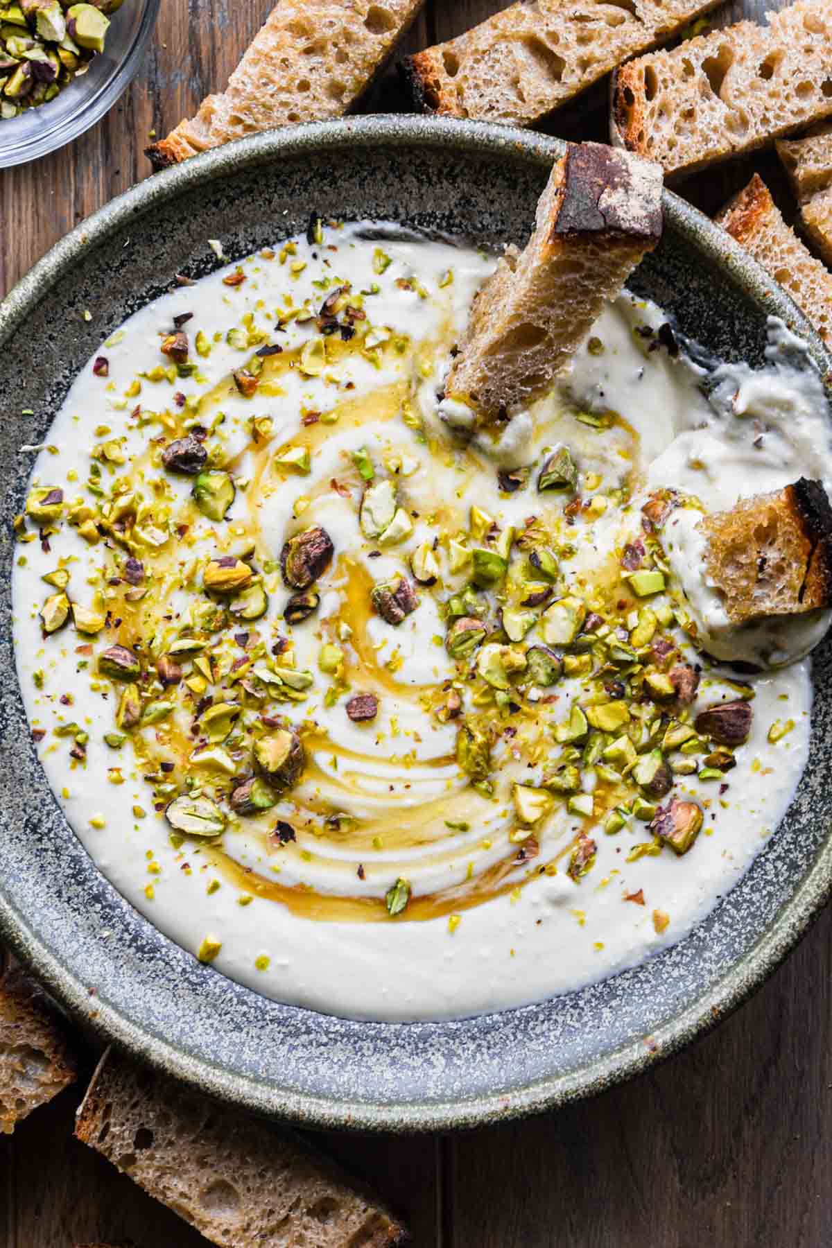 Feta dip in a bowl with honey and pistachios on top.