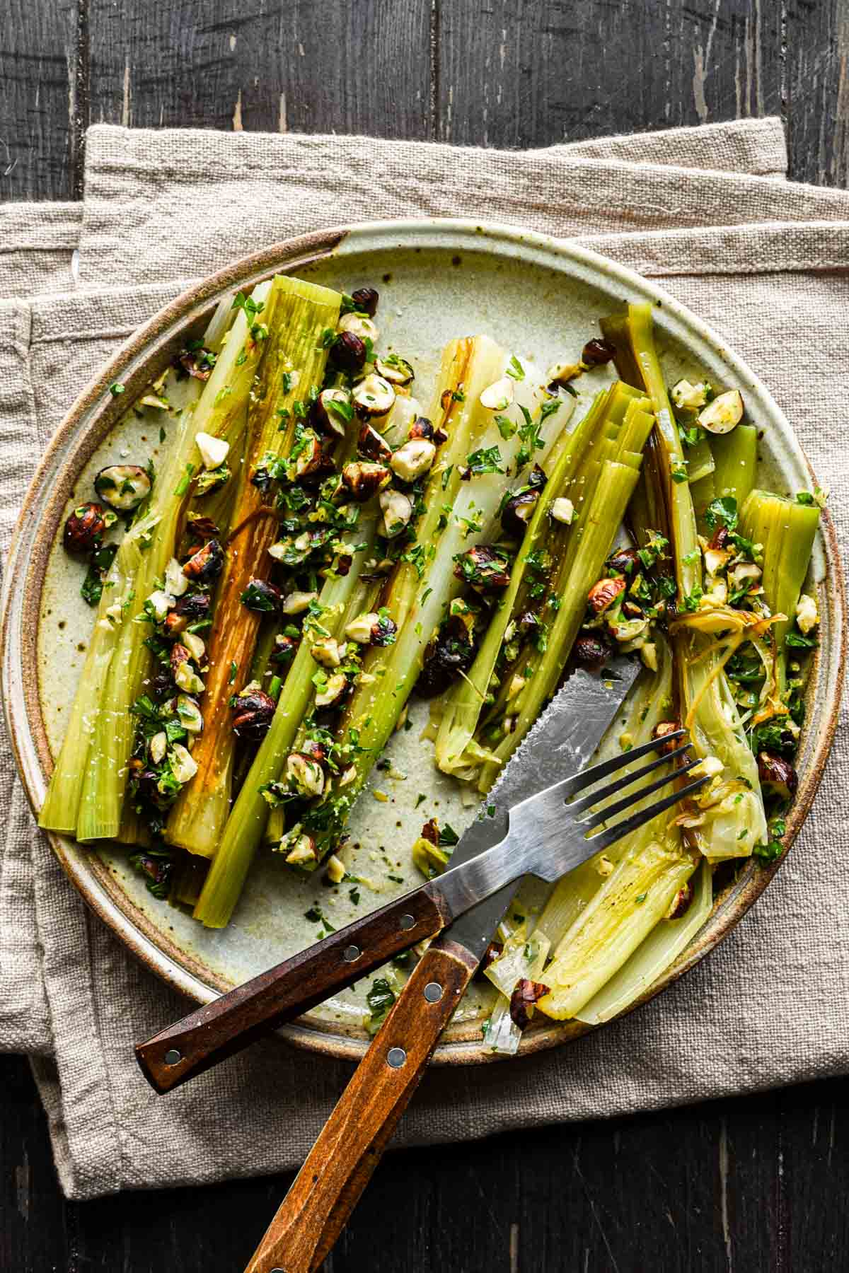 Plate of leeks with serving utensils.