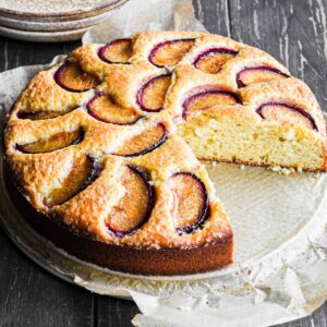 Plum cake with a slice taken out.