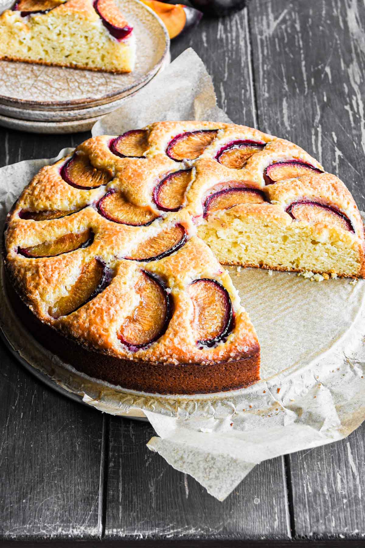 Plum cake with a slice taken out.