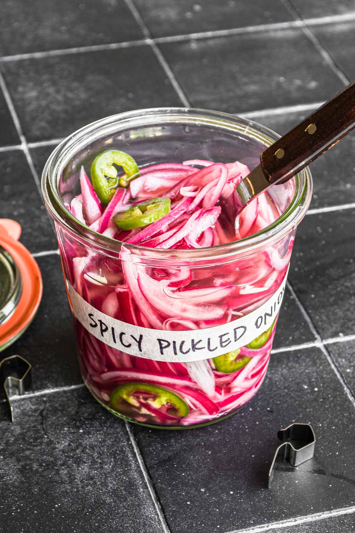 Spicy pickled red onions in a jar.
