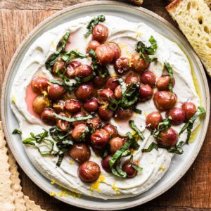 Whipped goat cheese on a serving platter with bread and crackers.