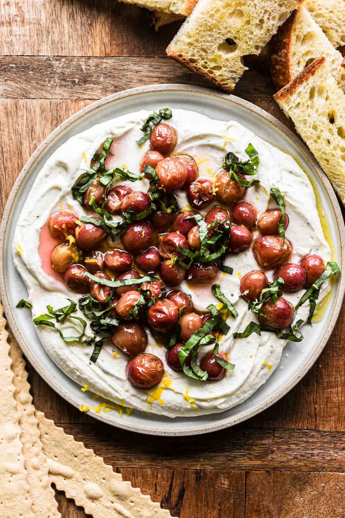 Whipped goat cheese on a serving platter with bread and crackers.