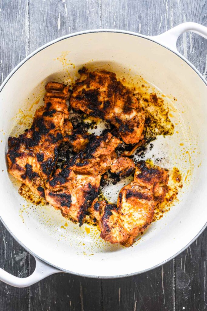 Searing the chicken in the dutch oven.