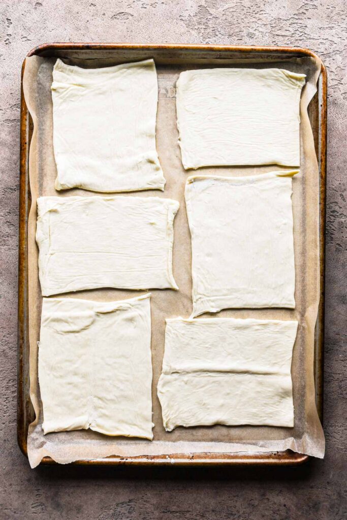 Cut puff pastry dough on a baking sheet.