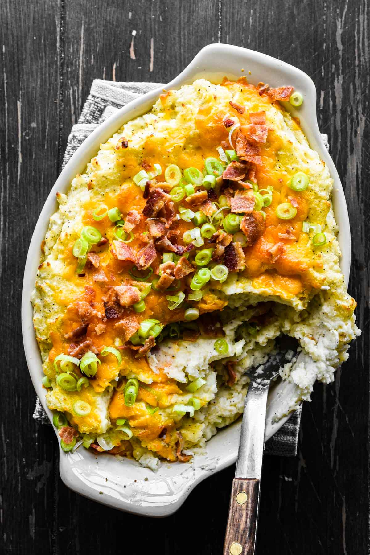 Close up image of spoon in mashed potatoes.