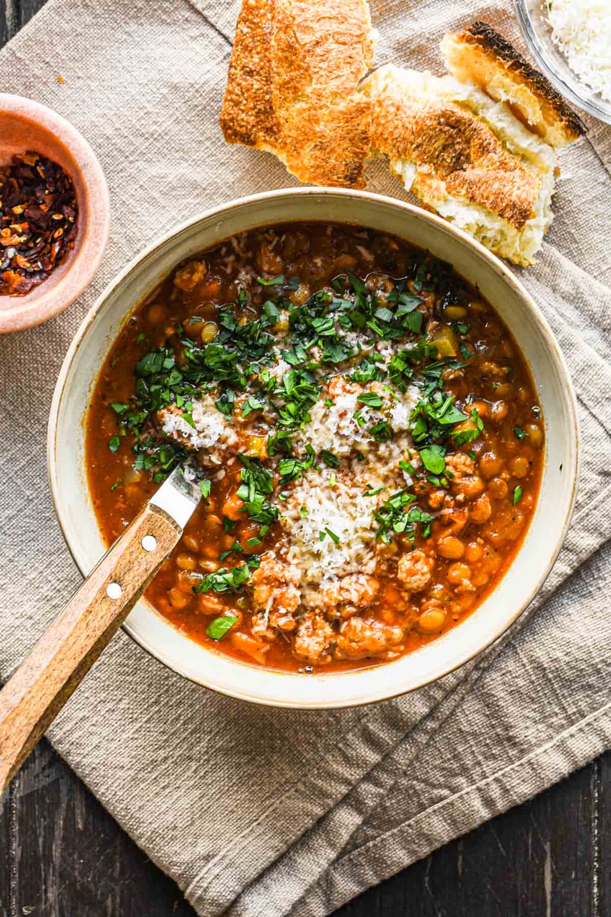 Turkey lentil soup in a bowl with parsley and parmesan.