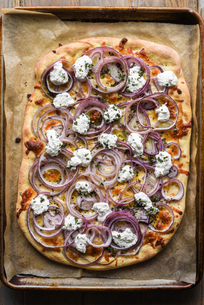 Finished onion pizza with ricotta and oregnano.