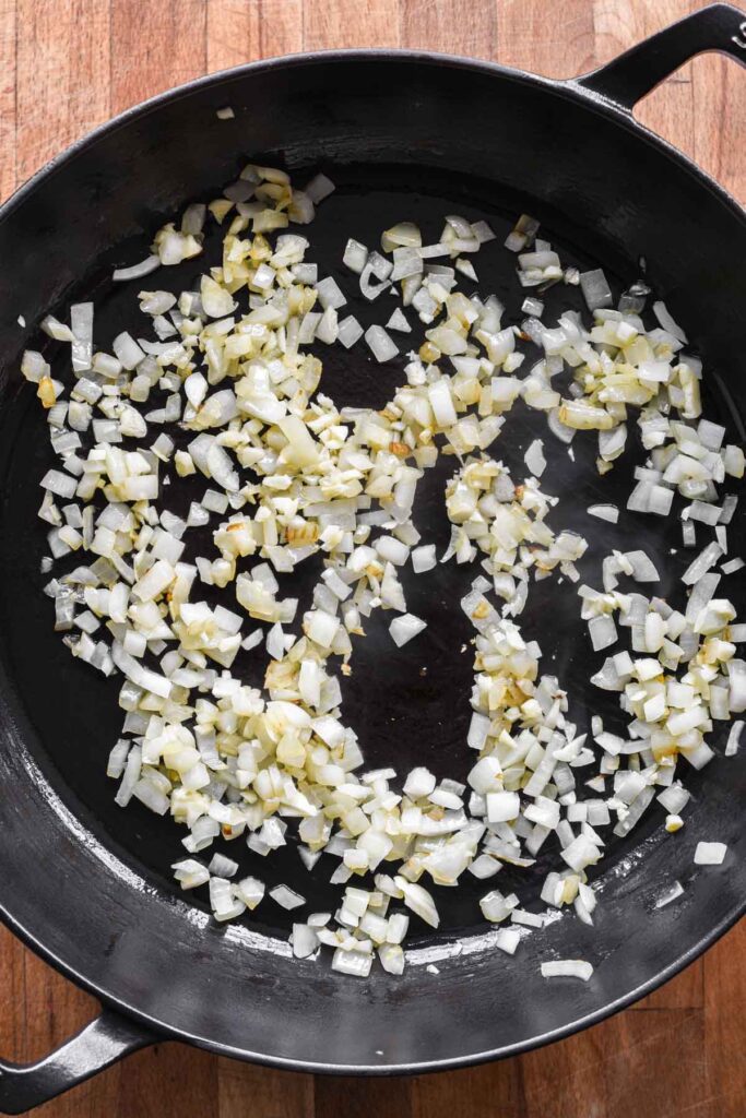 Garlic and onion sautéing in a skillet.