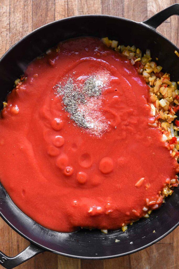 Tomato passata, salt, and pepper added to the onion mixture.