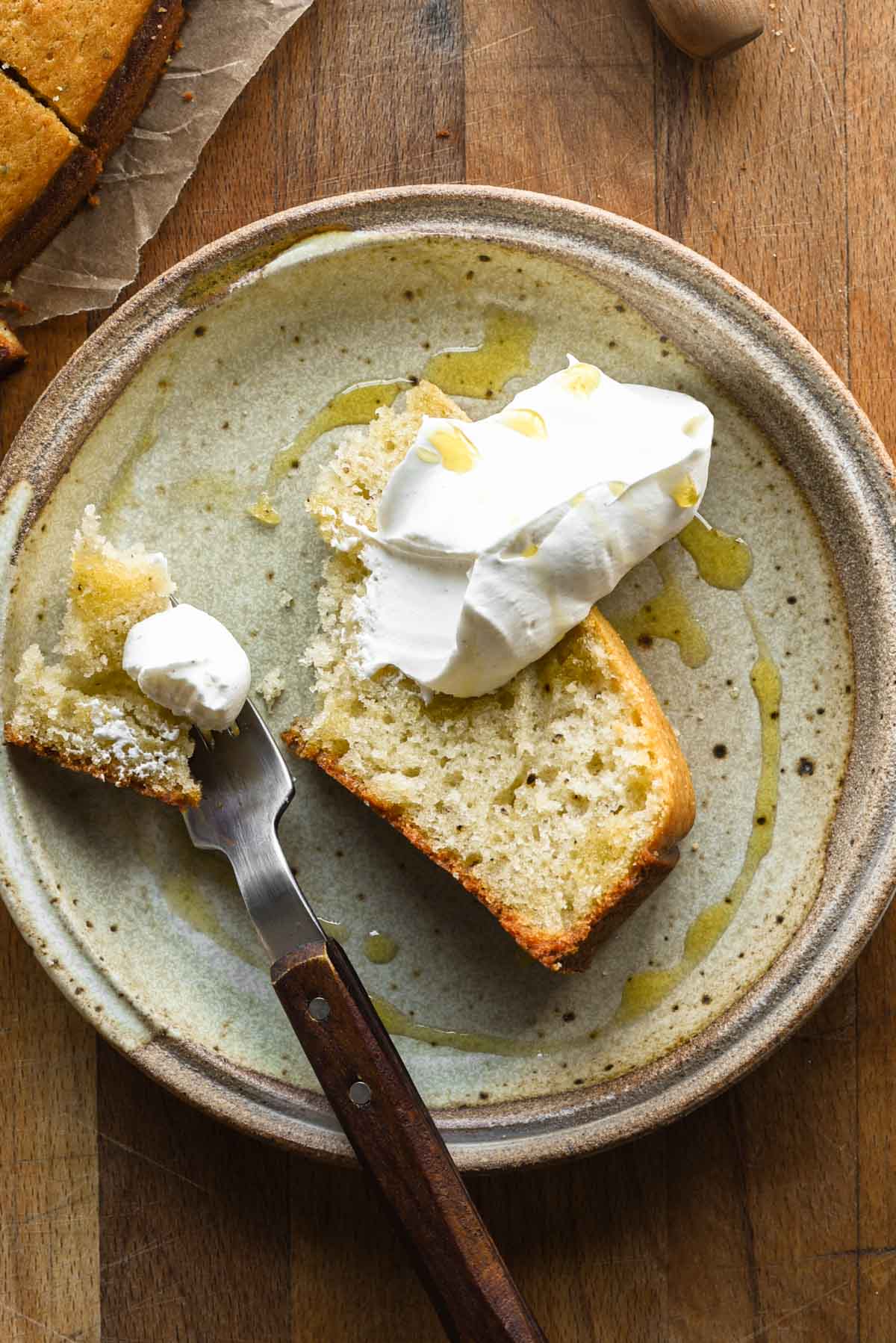 Slice of cake with whipped cream and a drizzle of olive oil.
