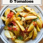 Finished roasted potatoes and tomatoes in a bowl.