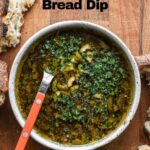 Olive oil bread dip on a board with bread.