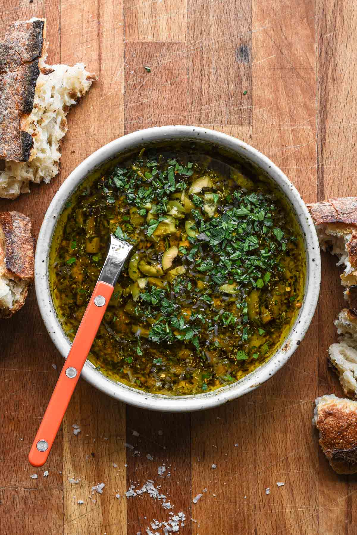 Balsamic and olive oil dip with orange spoon.