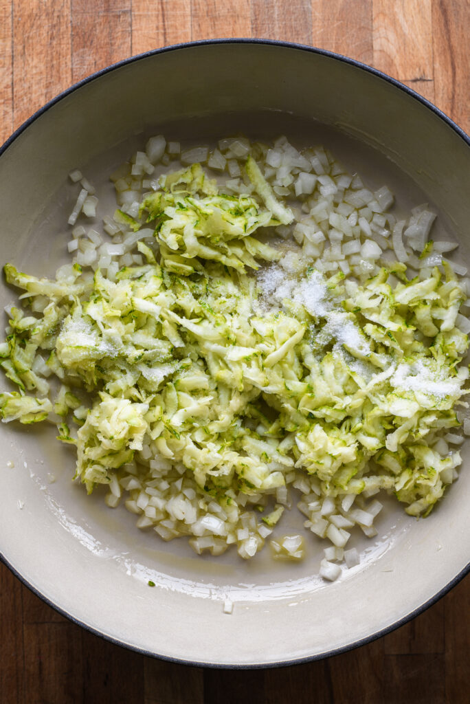 Adding zucchini to the pan.