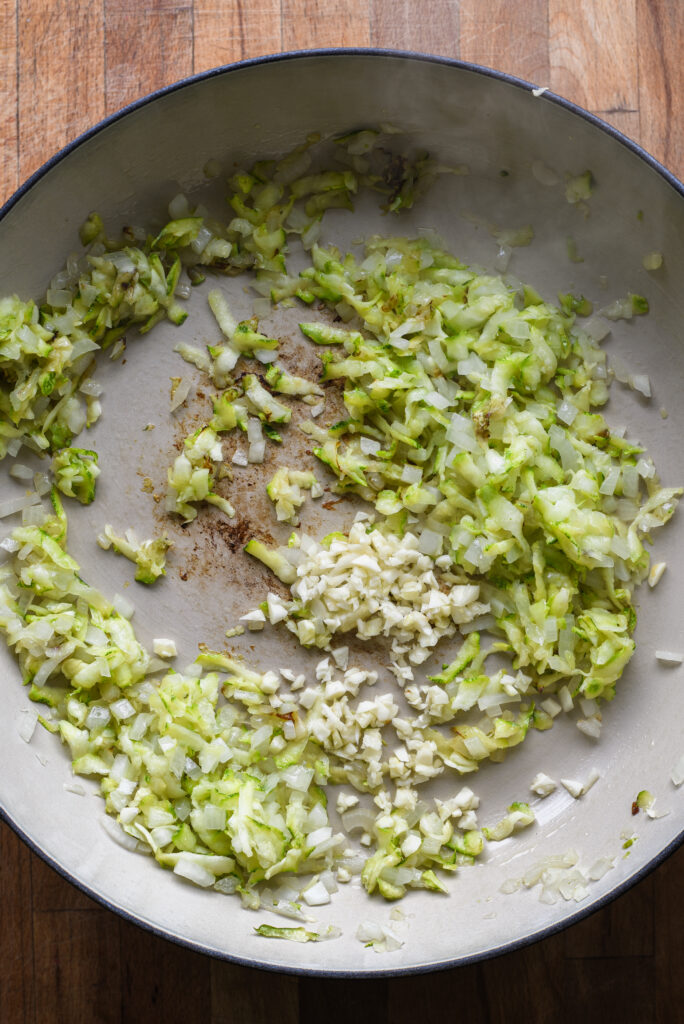 Adding garlic to cook.