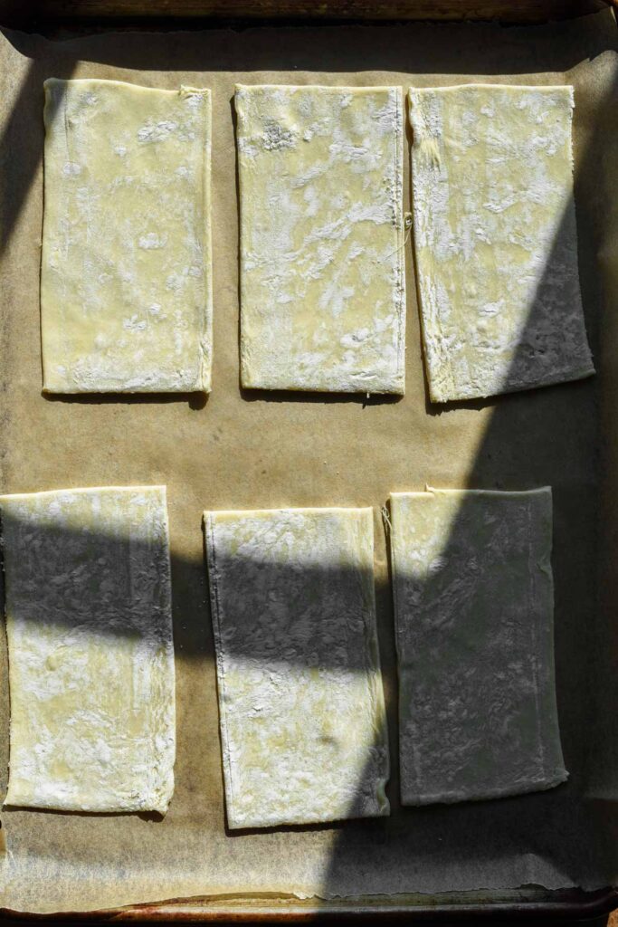 Puff cut into rectangles on a baking sheet.
