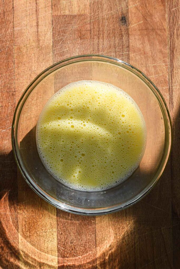 Egg wash in a glass bowl.