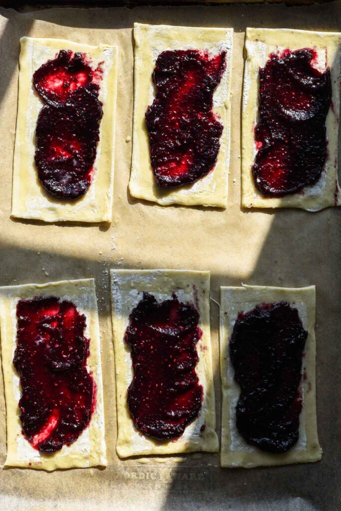 Bottom of puff pastry with jam and egg wash around the edges.