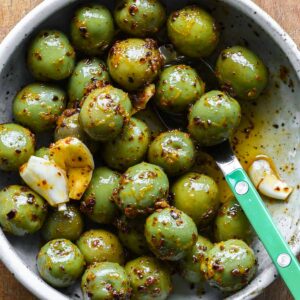 Close up photo of marinated olives in a serving bowl.