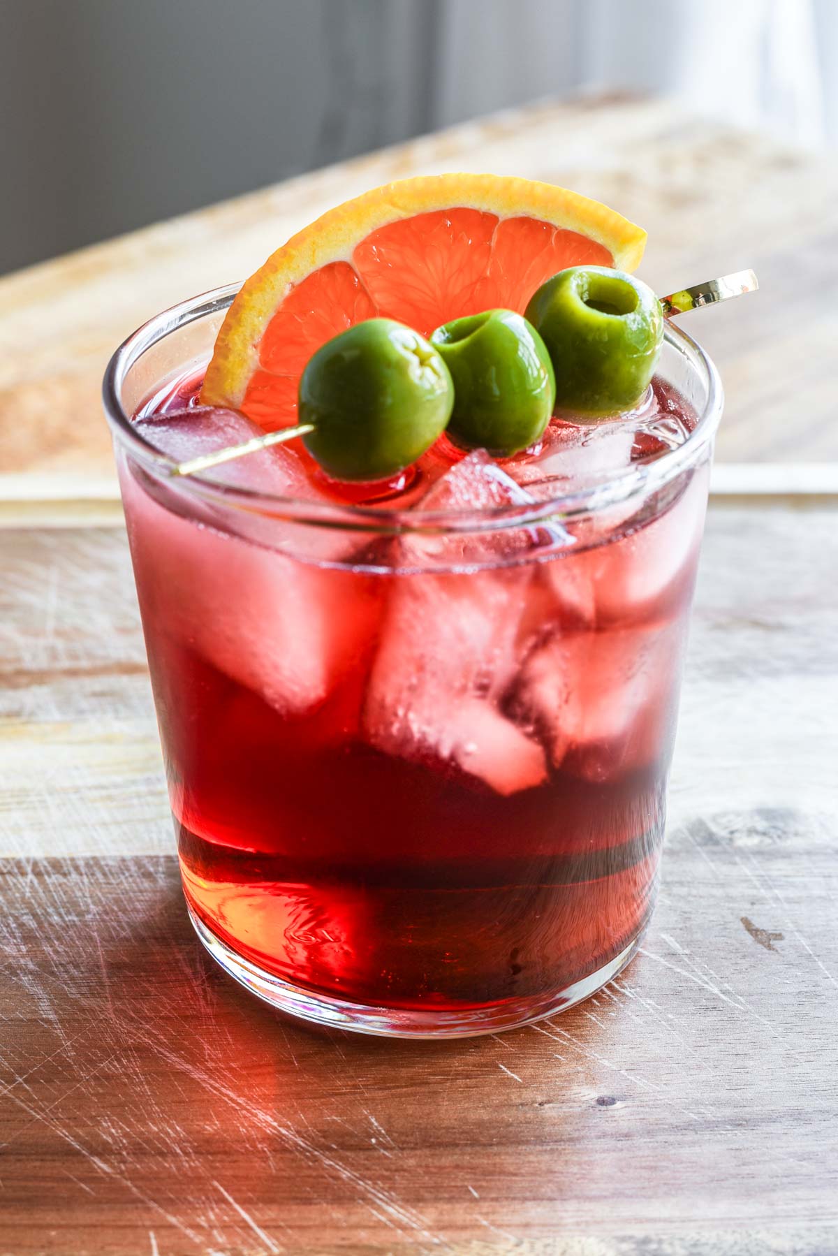 Lambrusco spritz with olives and orange slice.