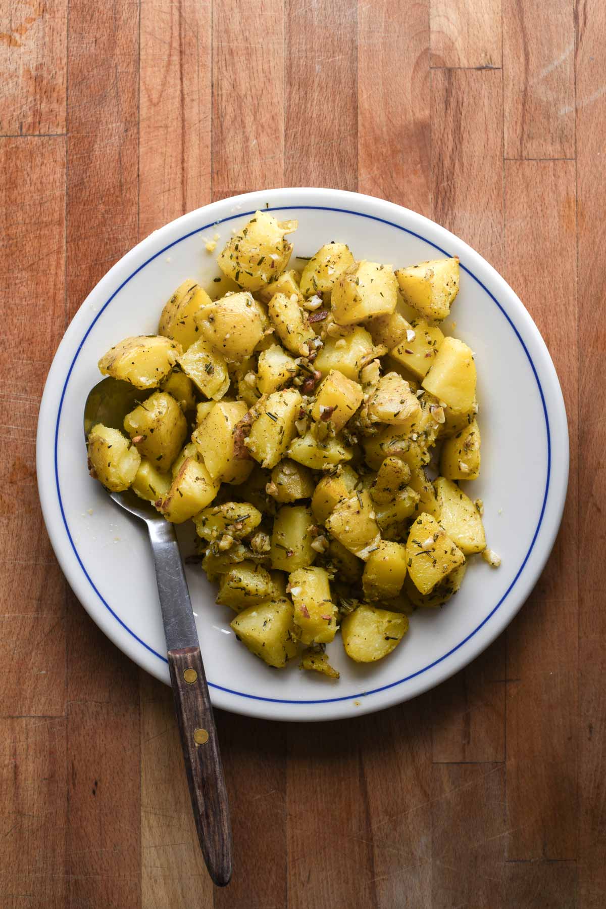 Potatoes on a serving plate with spoon.