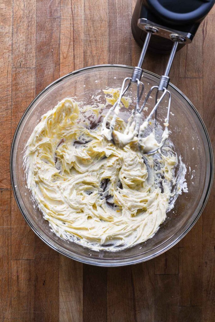Orange buttercream frosting in a bowl.