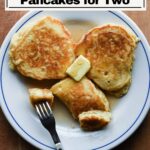 Pancakes on a plate with butter and syrup.