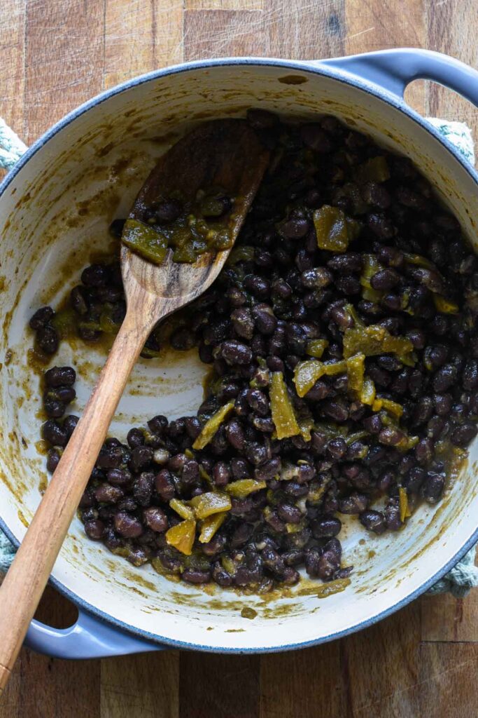 Cooked beans and chiles in a pot.