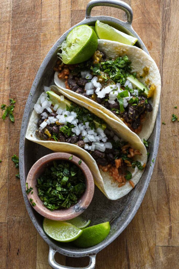 Assembled tacos in a silver platter.