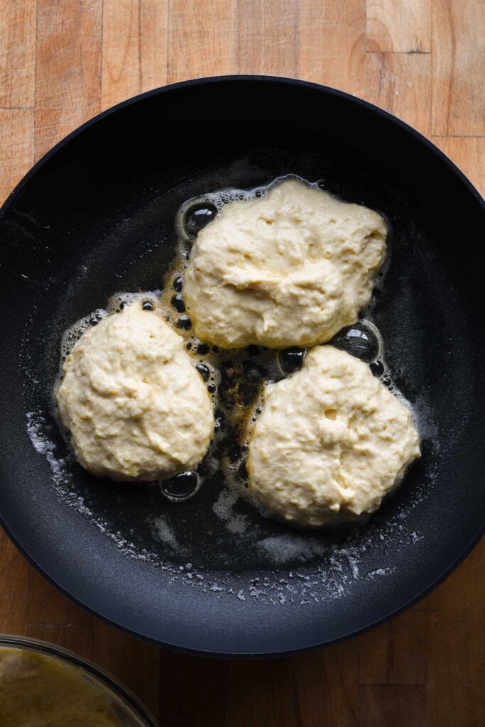 Batter dolloped into skillet with butter.