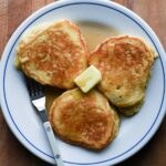 Close up of pancakes with a pat of butter and pure maple syrup.