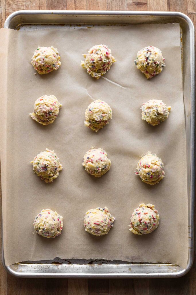 Cookie dough balls on baking sheet.